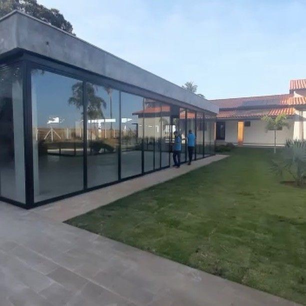 Casa de campo térrea com fachada contínua de vidro