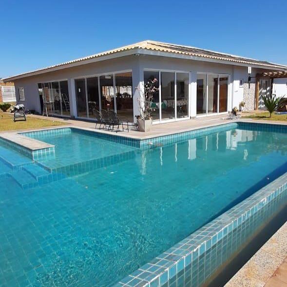Casa térrea com portas de correr de vidro voltadas para piscina