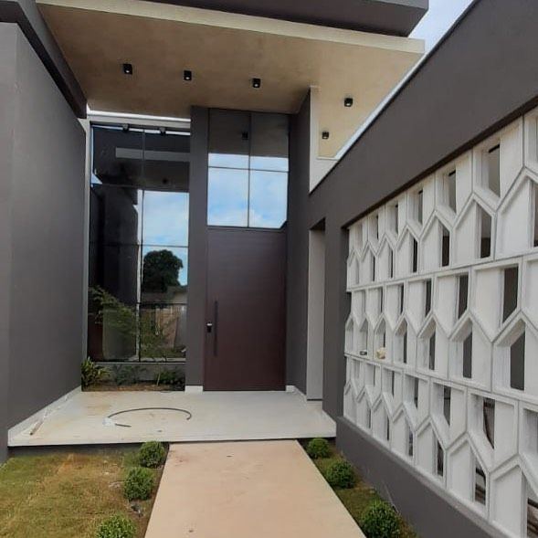 Entrada de casa com porta pivotante e vidro