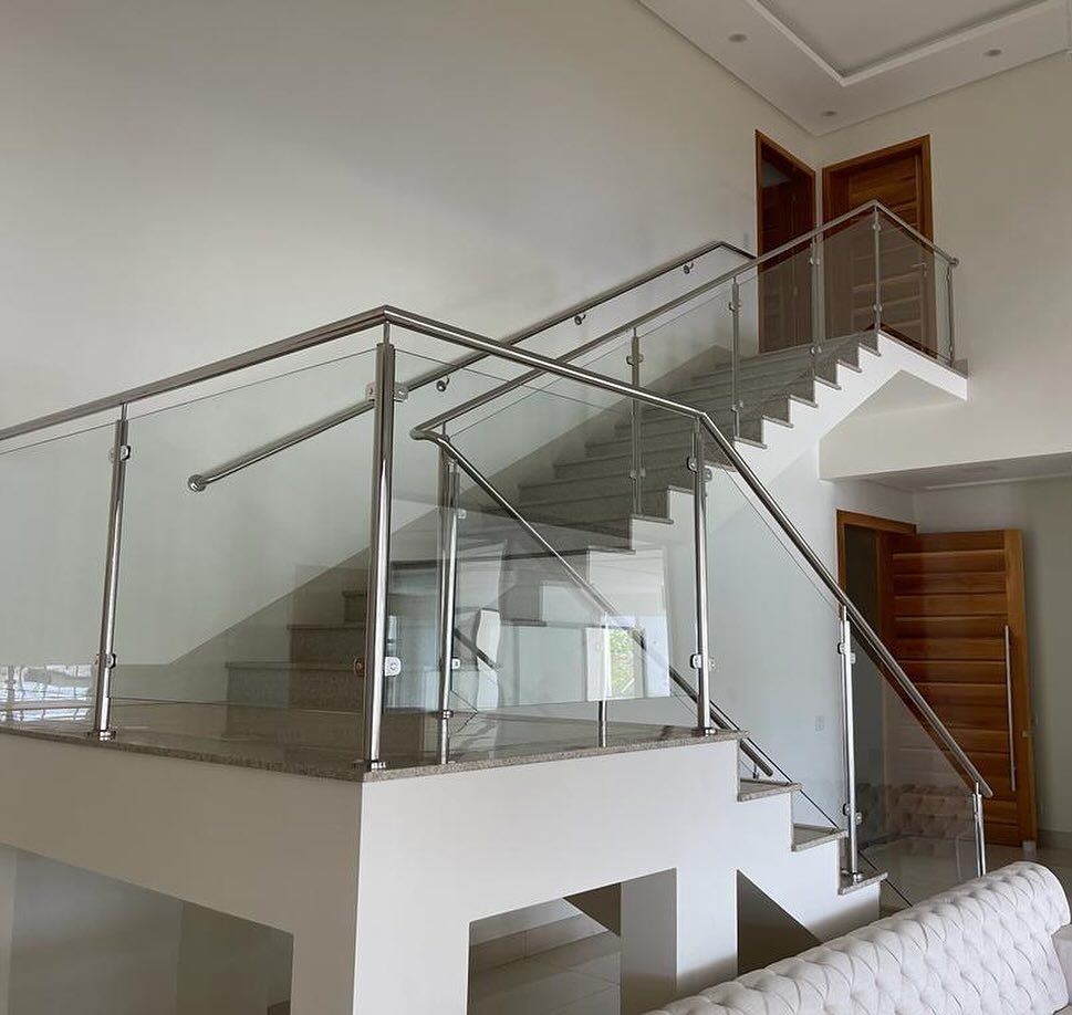 Escada com guarda-corpo de vidro e corrimão de inox