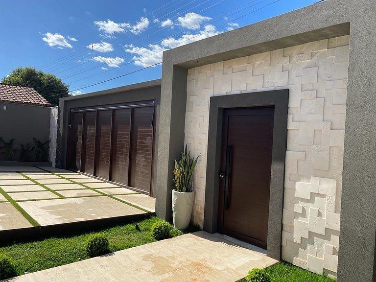 Fachada com porta pivotante e portão madeirado